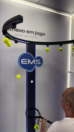 Ativação Reaction Ring no espaço da EMS durante o RIO OPEN 2026, com participante dentro da estrutura semicircular interativa enquanto o público acompanha ao redor em ambiente de evento esportivo.