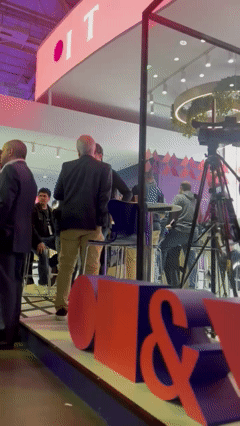 Público interage com totem AI Booth na ativação da CI&T na FEBRABAN. Participante escolhe como se imagina no futuro e recebe foto personalizada com tecnologia de inteligência artificial.