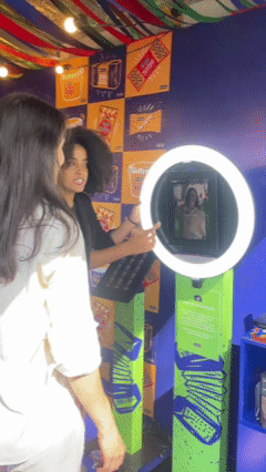 Participante tira foto no AI Booth da Santa Helena durante a Festa Junina do Clube Pinheiros e recebe imagem impressa no estilo Cordel.