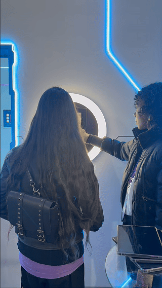 Participantes utilizam a ativação AI Booth no estande da Sabesp durante a SP Innovation Week 2026, realizando capturas fotográficas transformadas por inteligência artificial com impressão instantânea e conteúdos personalizados.