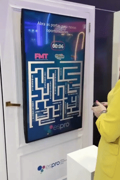 Participantes jogam game interativo inspirado em Pacman no estande da Espro durante o CONARH 2025. A ativação, criada pela Phygital Solutions em parceria com a agência Beez, permitia escolha de avatar, cenários e promovia engajamento com propósito.