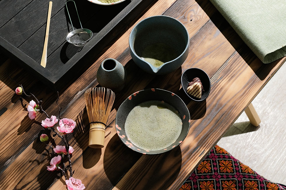 Japanische Matcha-Teeszene mit Chawan, Chasen, Blüten und Süßigkeit