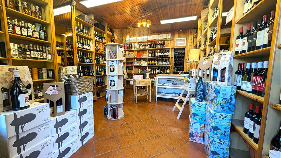 Interno di A Casa Fuori con scaffali di vini e confezioni, enoteca in zona Tuscolana a Rom