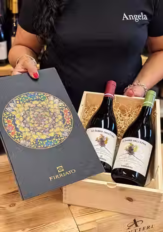 Angela presenta una confezione regalo Firriato con vini selezionati nell’enoteca A Casa Fu