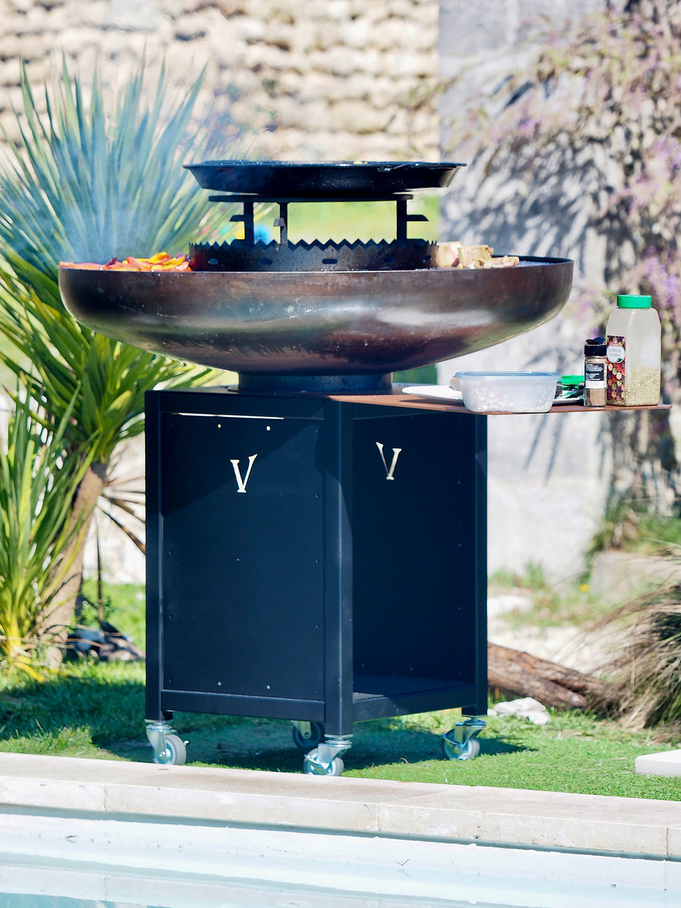 Miniature : brasero rond sur socle thermolaqué noir traversant Vulcan brasero au bord d'une piscine 
