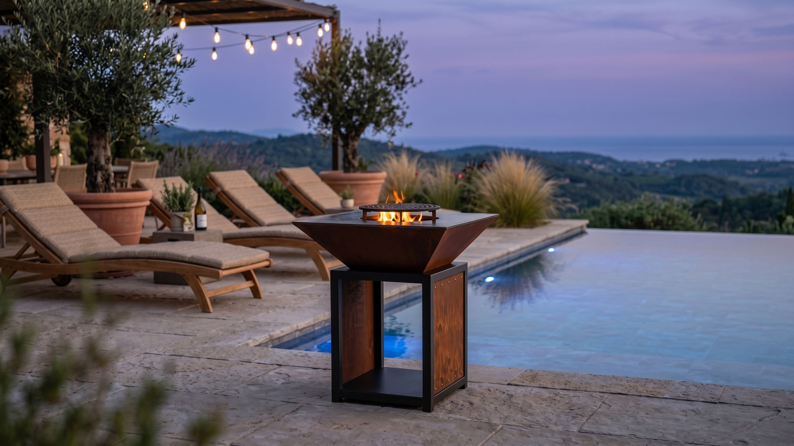 brasero carre sur socle thermolaqué noir vulcan brasero au bord d'une piscine au coucher du soleil
