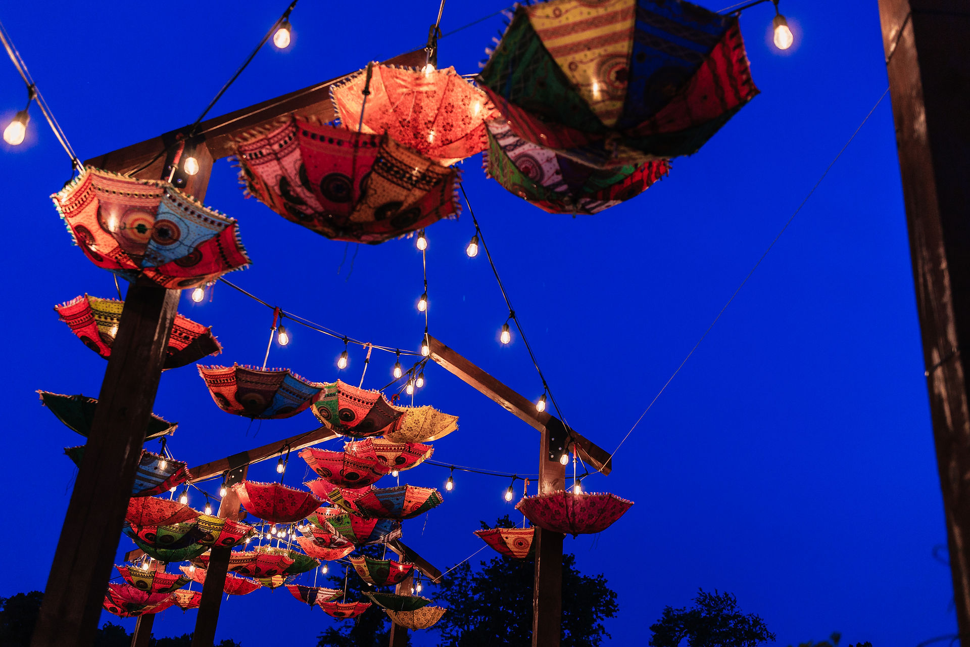 overhead colorful umbrellas and bistro lights in the dark