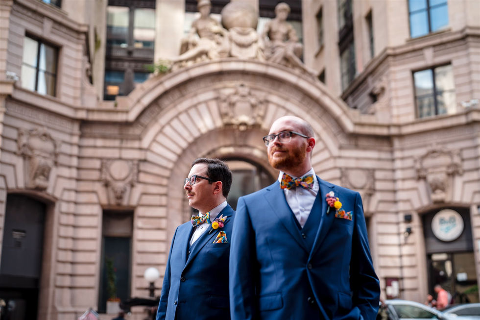 two grooms in blue standing on a street in baltimore