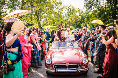 groom in red convertible in baraat