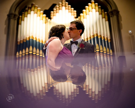 bride and groom in front of pipe organ
