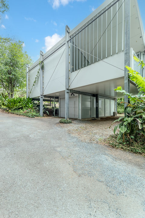 A house nestled amidst lush greenery, surrounded by trees and plants.