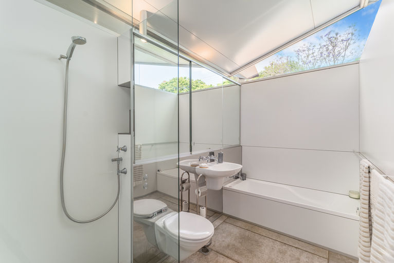 An image of a bathroom with a shower, toilet, and sink.