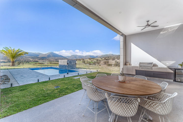 Outdoor patio with table, chairs, and pool with a view