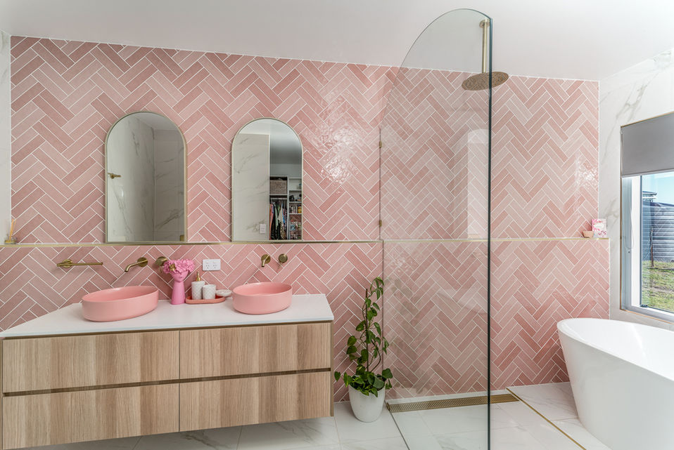 Bathroom featuring pink tiling and glass shower
