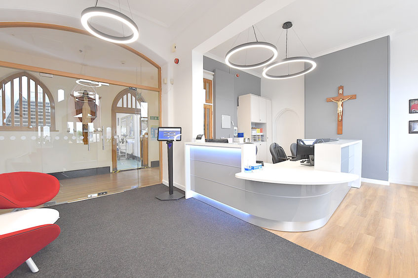 Curved white reception desk creating a bright and welcoming entrance space for a modern school environment