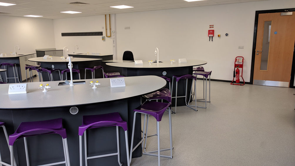 Collaborative teaching laboratory with circular lab bench seating designed for practical science education and group learning