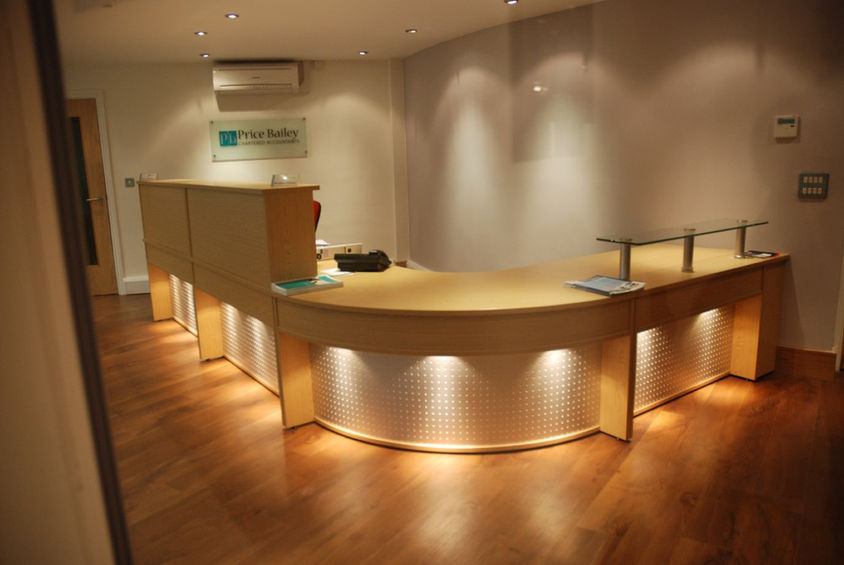 Warm ambient lighting and curved timber detailing adding a professional feel to this refurbished reception area