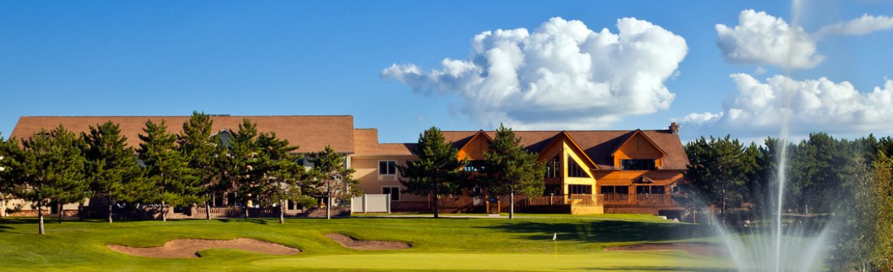 Thumper Pond Resort lodge seen across the golf course, with a fountain and pines