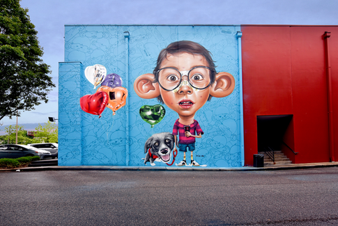 1º mural: Como todos os outros personagens “Big Ears”, este remete ações do mundoinfanto-juvenil. Neste é o menino já com espinhas e um curativo para esconde-las (masno caso chamando mais atenção). Em uma ação passeando com seu cão e tomandorefrigerante. Os balões possibilitam o publico a interagir com a arte.
First Wall: just like all the other “Big Ears” characters this wall refers to thejuvenile and kids’ world. This one is of a boy that has pimples and is using aband-aid to hide some of it. My intention was to use the bandage to attractmore attention to the piece. The boy is walking with his dog and drinkingsoda. I also added balloons to allow people to interact with the art.