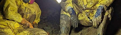 Technician in protective gear performing mold remediation in a residential basement in Michigan