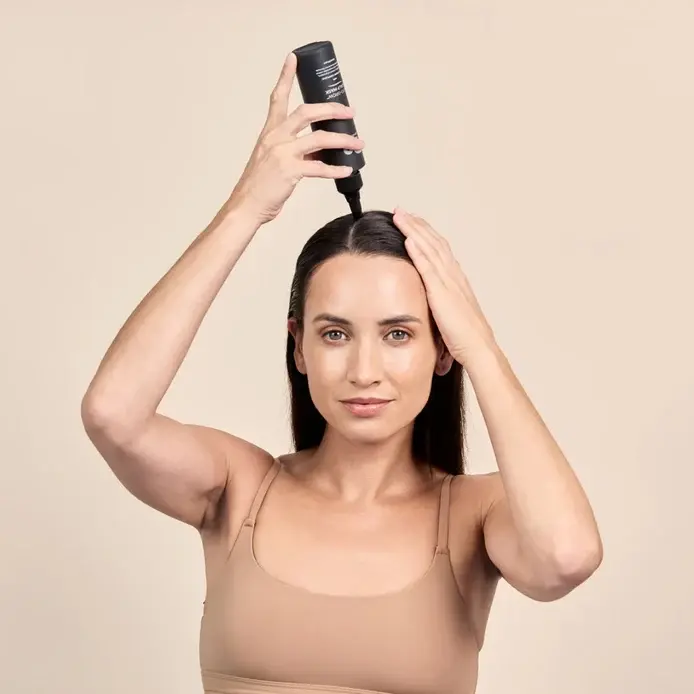 Thumbnail: Woman applying DP Dermaceuticals Exo-Grow Scalp Mask to support healthier-looking hair and scalp on a clean beige background.