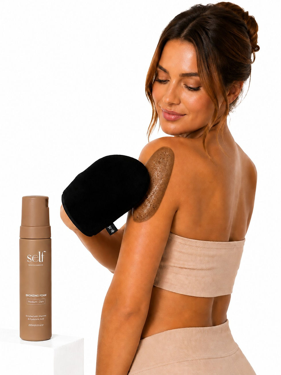 Model applying self tan with the SELF Tan by O Cosmedics Velvet Tanning Mitt for a smooth, streak-free bronzed finish