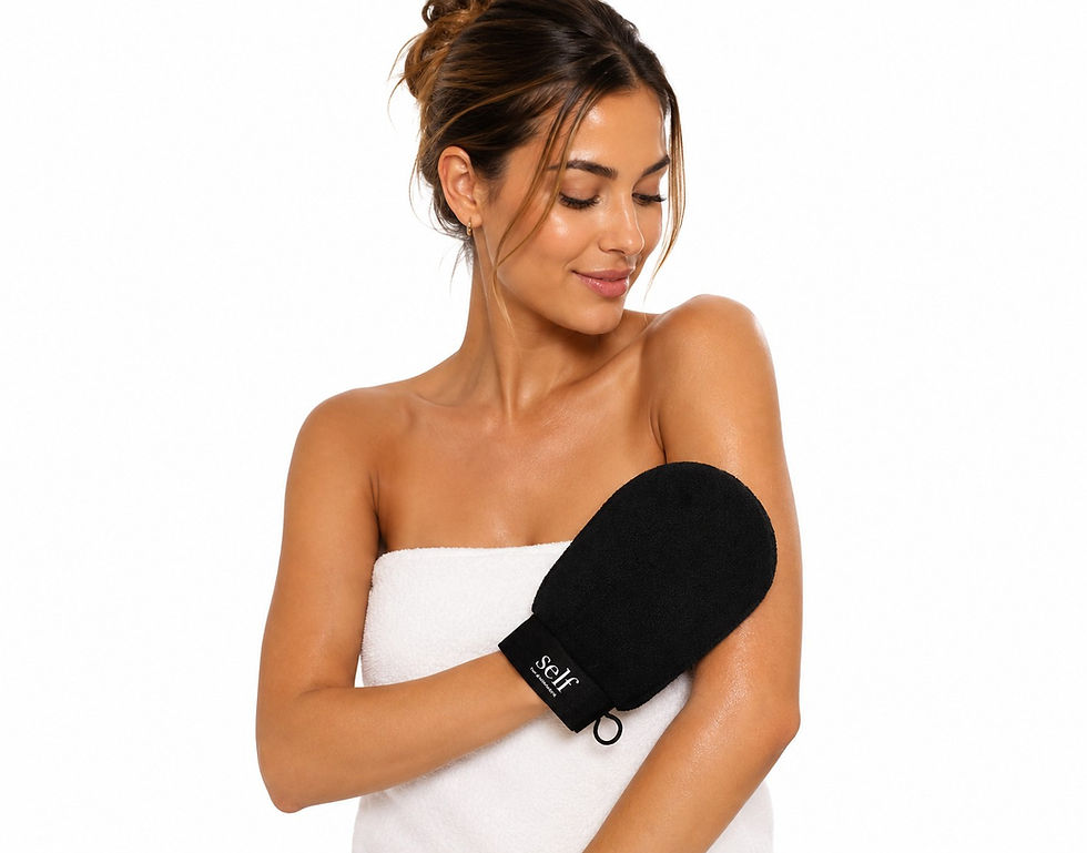 Model using the SELF Tan by O Cosmedics Exfoliating Glove to gently remove dead skin cells and prepare skin for a smooth, str