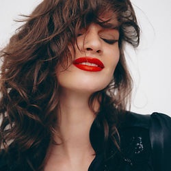 Girl with wavy hair and red lips smiling and looking content