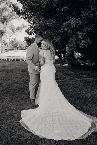 A black and white image of the bride and groom overlooking a vineyard and posing for the wedding photographer.
