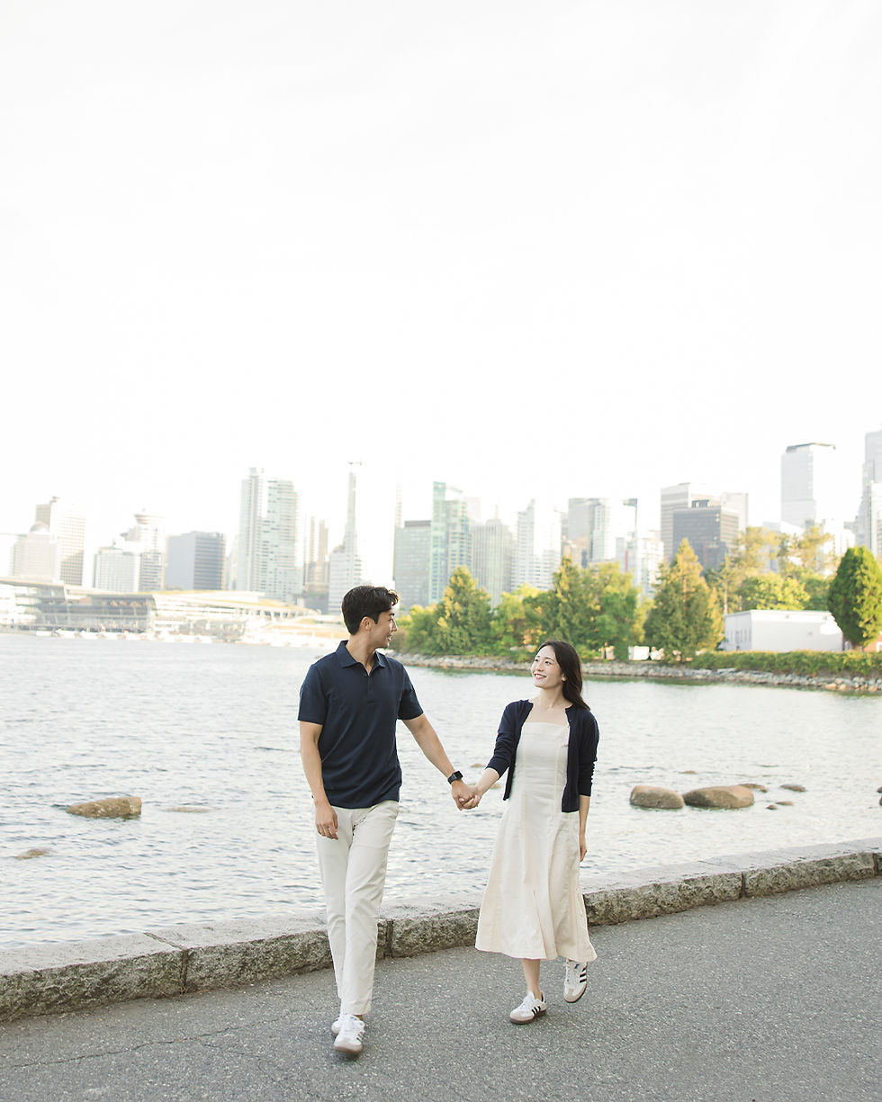 Romantic engagement photos in Vancouver with city skyline and ocean view at Stanley Park