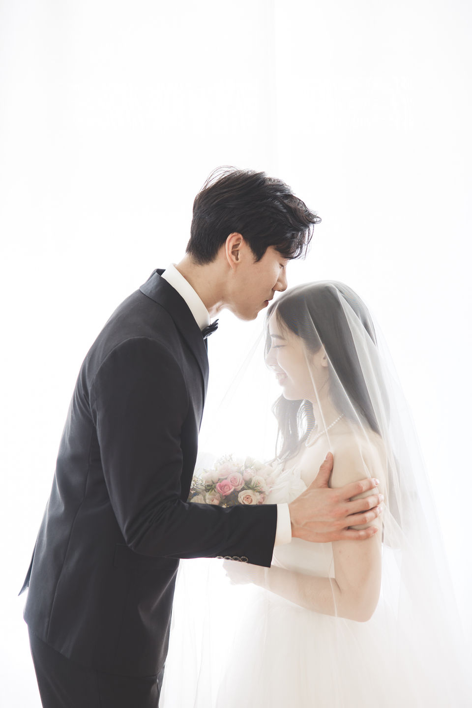 Couple kiss in front of the Window during prewedding photoshoot session