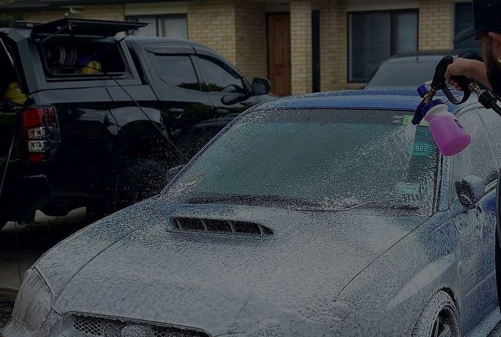 Out-of-focus car undergoing professional auto detailing, highlighting before-and-after surface correction context