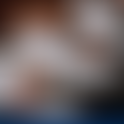 Meeting with people in suits reviewing contracts at a wooden table. Papers, pens, and documents are scattered. Focused, professional mood.