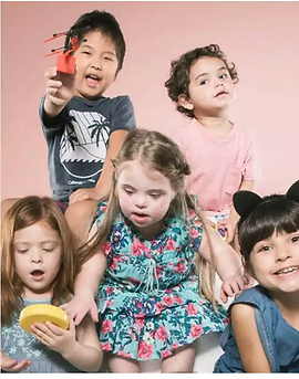 cinco crianças brincando, entre elas uma menina com sindrome de down.