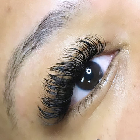Side view close-up of classic lash extensions on brown eyes
