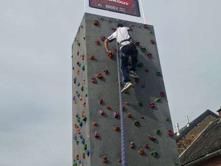 Een klimmer op de K2Evasion-klimtoren tijdens de Milwaukee Challenge bij Gedimat KM Matériaux in Jalhay.