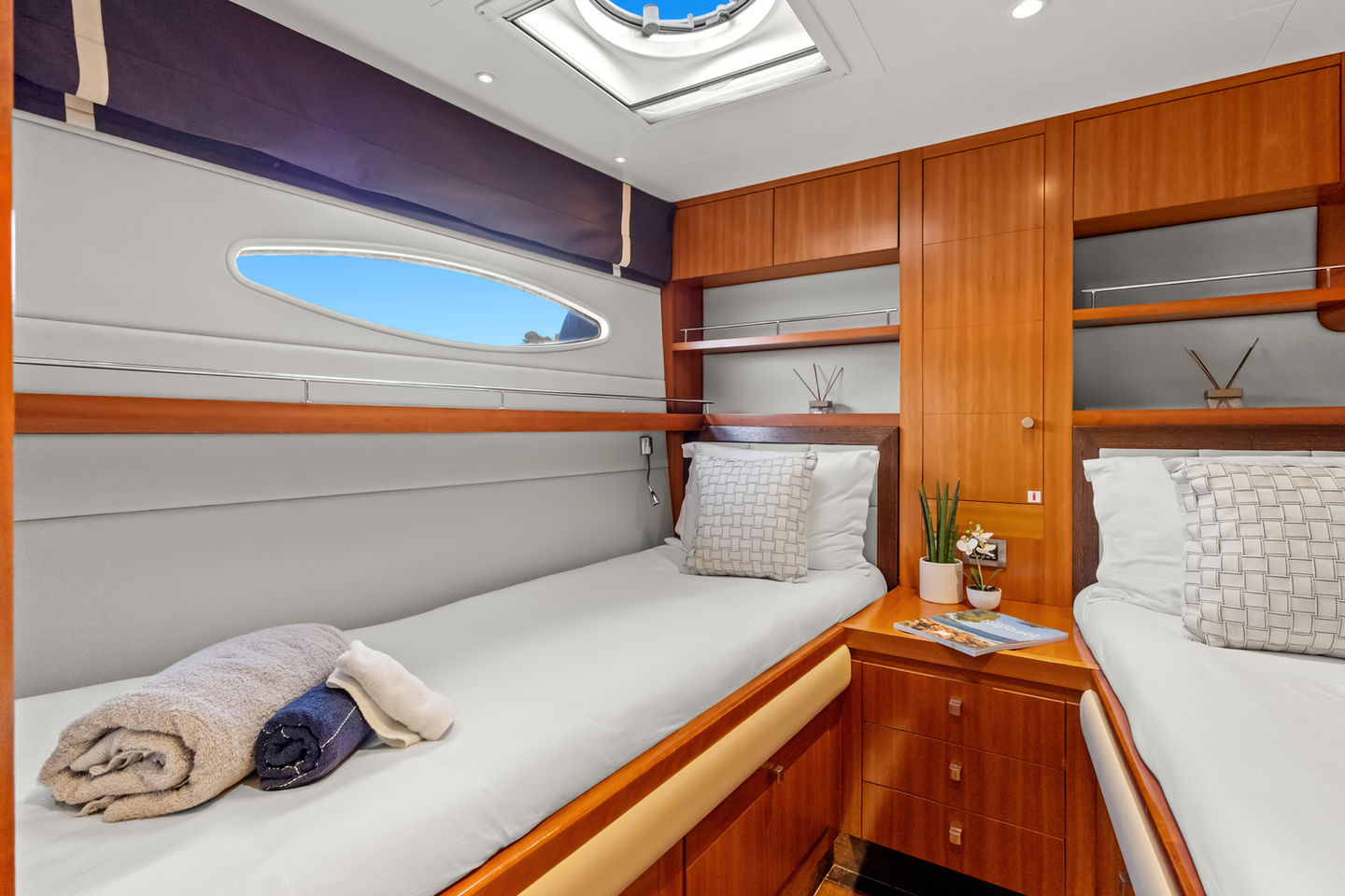 Cabine de luxe du catamaran Moby-Dick avec deux lits jumeaux, espaces de rangement et salle de bain privative