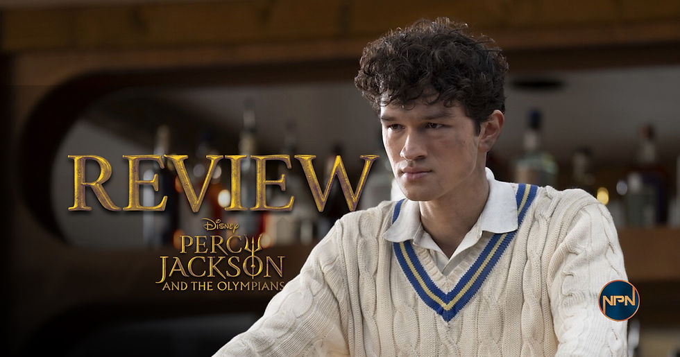 Charlie Bushnell as Luke Castellan in a white sweater with blue stripes over a white collared shirt. Text reds "Review Percy Jackson and the Olympians"