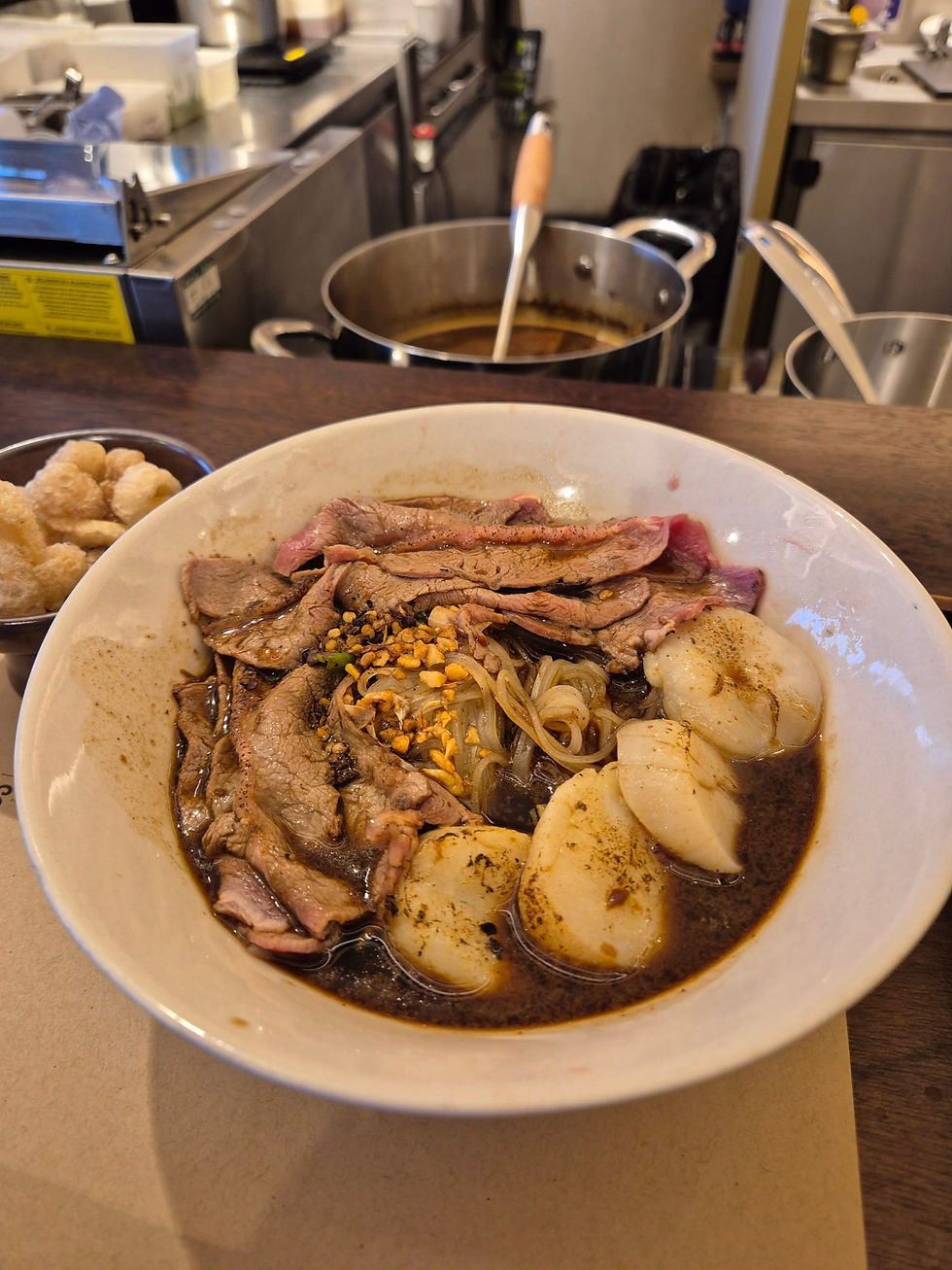 a bowl of beef broth, noodles and scallops