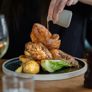 gravy being poured onto a Sunday roast
