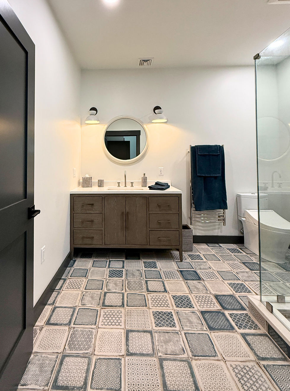 a bathroom with pattern tile floor and a wooden vanity