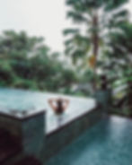 Woman relaxing in a pool overlooking the jungle