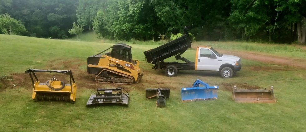 An ASV Compact Track Loader beside a Ford F-350 Dump Truck and 5 attachments including a Forestry Mulcher, Grading Blade, Excavator Hoe, Brush Cutter / Bushhog and a 4-in-1 Bucket