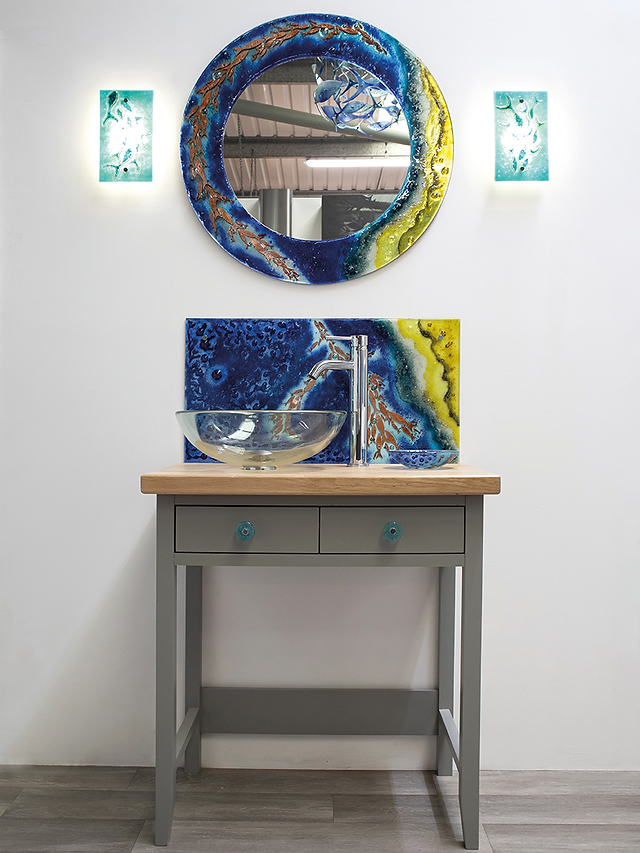 fused glass art inspired by the Cornish coast created by Jo Downs Handmade Glass in Cornwall. Contemporary fused glass wall art, decorative panels and artisan glass designs handcrafted in a Cornish studio. Handmade fused glass artwork featuring coastal colours, ocean textures and light inspired by Cornwall’s shoreline. Jo Downs glass fusion artwork including wall panels, triptychs and statement installations designed for luxury interiors. Artisan fused glass collection handcrafted in Cornwall featuring wave panels, surfboard panels and coastal wall art. Bespoke fused glass commissions for homes including decorative glass panels, mirrors, splashbacks and architectural installations. Handmade Cornish glass giftware including jewellery, dishes, coasters, bowls, vases and glass hangings inspired by sea, sand and sky. Shoaling fish fused glass collection inspired by marine life and Cornish coastal waters. Coastal themed glass art including starfish, dolphins, gulls and sailing boats in layered fused glass designs. Contemporary glass wall panels such as Gwithian, Polperro and Cornish coastline inspired artwork. Signature Jo Downs fused glass designs reflecting Cornwall’s changing light and coastal landscapes. Luxury handmade glass home accessories crafted in Cornwall including mirrors, art frames and decorative vases. Glass fusion artwork using fritted glass, enamel and kiln formed techniques to create texture and depth. Jo Downs glass galleries in Cornwall including St Ives, Padstow, Fowey, Tintagel and Launceston studio gallery. Contemporary fused glass interior design pieces designed for modern homes and coastal interiors. Glass fusing workshops in Cornwall at the Jo Downs Launceston studio where visitors create coasters, dishes, wall art and decorative fused glass pieces. Handmade Cornish glass art gifts inspired by the colours of the sea and the landscapes of Cornwall.