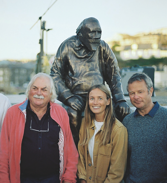 Hugh Fearnley-Whittingstall, Holly Bendall and The Real DaveThree people smiling beside a bronze seated statue outdoors, with a blurred waterfront background in soft daylight.