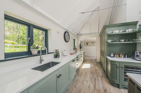 bespoke wooden kitchens and handcrafted furniture designed by Rozen Furniture on the Lizard Peninsula Cornwall. Custom made kitchens, cabinetry and joinery crafted by Rozen workshop in Ruan Minor Cornwall. Handcrafted solid wood kitchens built using traditional cabinet making techniques in Cornwall. Luxury bespoke furniture and fitted interiors created by Cornish craftsmen at Rozen Furniture. Custom cabinetry, wardrobes and storage solutions handmade in Cornwall workshops. Bespoke kitchen design featuring tulip wood doors, oak carcasses and dovetailed drawer boxes. Hand painted kitchens with traditional brush finish crafted by Rozen Furniture Cornwall. Solid oak kitchen islands and bespoke cabinetry designed for contemporary homes in Cornwall. Handmade furniture including bookcases, media walls and drinks cabinets built by Rozen craftsmen. Floor to ceiling bespoke bookcase with ladder rail and integrated lighting in Cornwall home interiors. Luxury fitted furniture and joinery designed for architects and interior designers across the UK. Custom walnut media walls and oak shelving units designed for modern living spaces. Bespoke furniture production process including 3D design, cabinet making and workshop assembly in Cornwall. Sustainable timber furniture using tulip wood and oak sourced from responsibly managed forests. Rozen Furniture Cornwall specialising in handcrafted kitchens, bespoke cabinetry and luxury interior joinery.