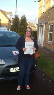 Pupil standing next to skillz driving school car.