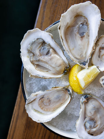 Fresh oysters on ice with a lemon wedge
