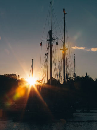 Sunset behind silhouetted sailboat masts