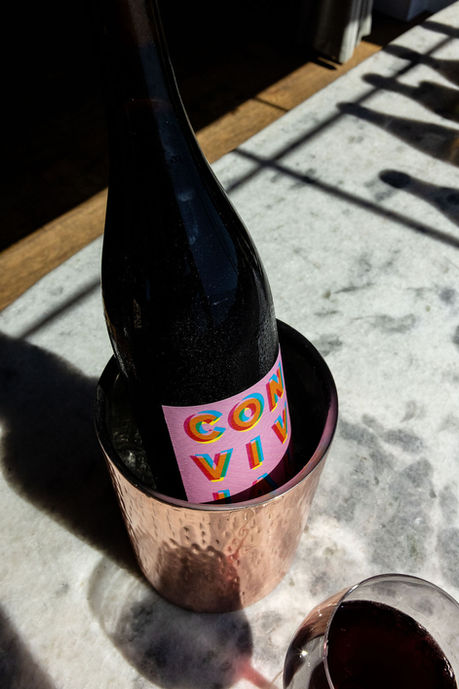Wine bottle with colorful label in copper cooler on marble